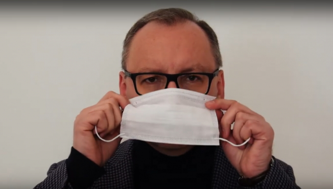 aktor filmu instruujący jak zakładać maseczkę. link prowadzi do filmu instruktażowego. 